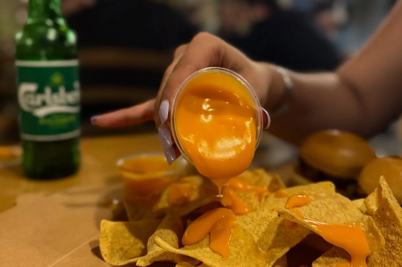 Nachos με λιωμένο τυρί και παγωμένη μπίρα στο τραπέζι